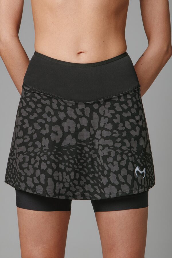 A model in a black and gray running skirt with built-in shorts and back pockets. All made of high-performance fabrics.