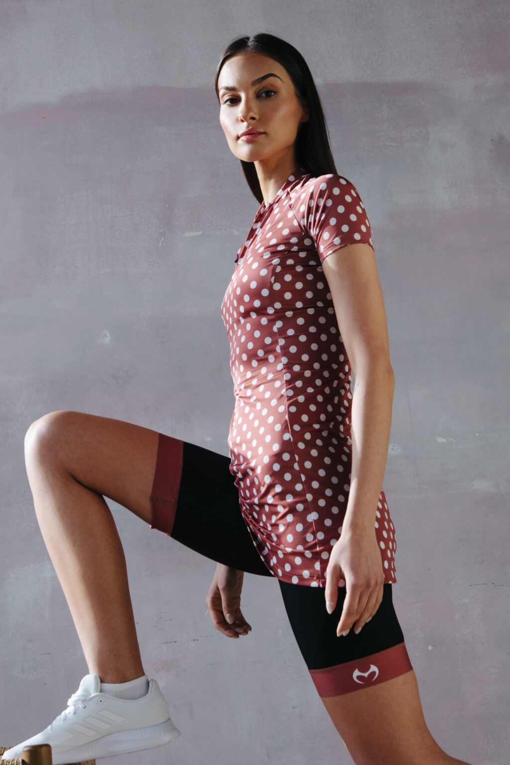 A model in a sporty brown dress with white polka dots, fastened with a zipper.
