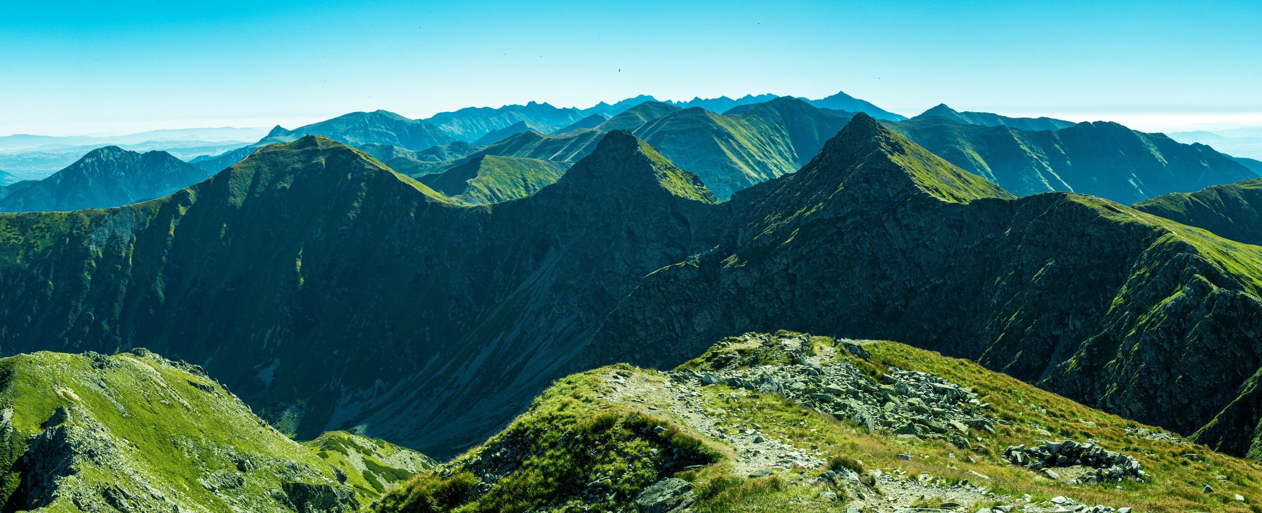 View of the trail leading along the ridge of the Tatra Mountains in sunny weather.